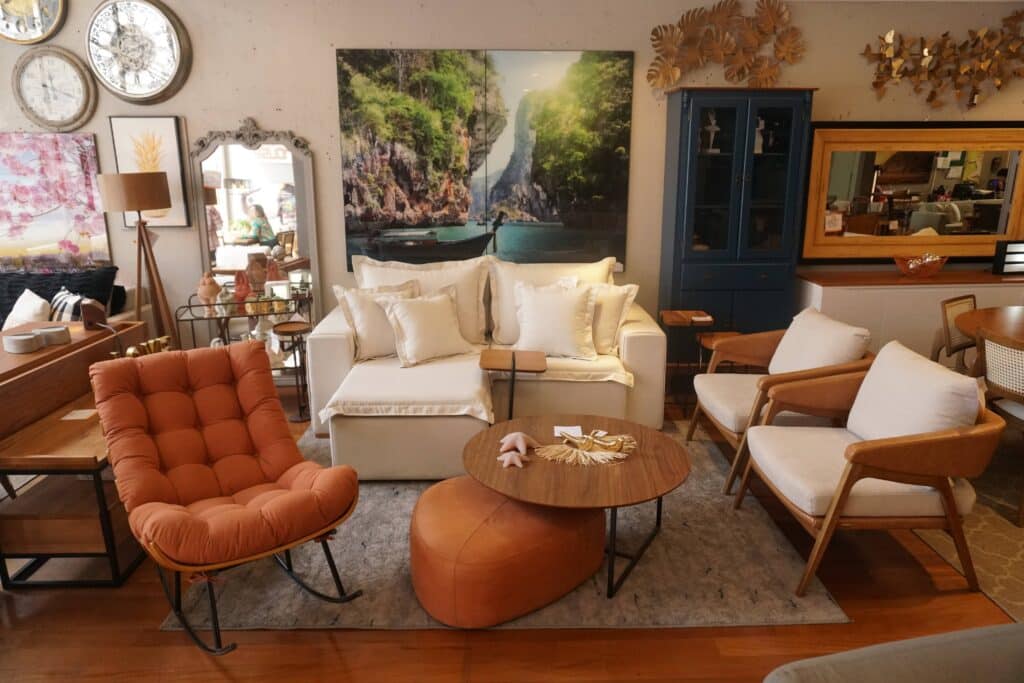 sala de estar com sofa, poltronas, quadros, armários e mesa